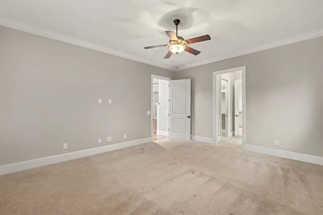 a view of an empty room with a chandelier fan