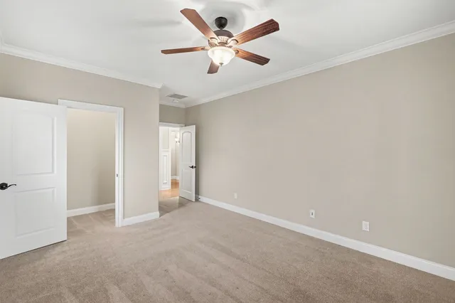 an empty room with closet and a ceiling fan