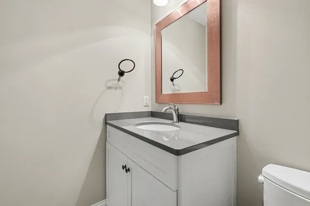 a bathroom with a granite countertop sink and a mirror