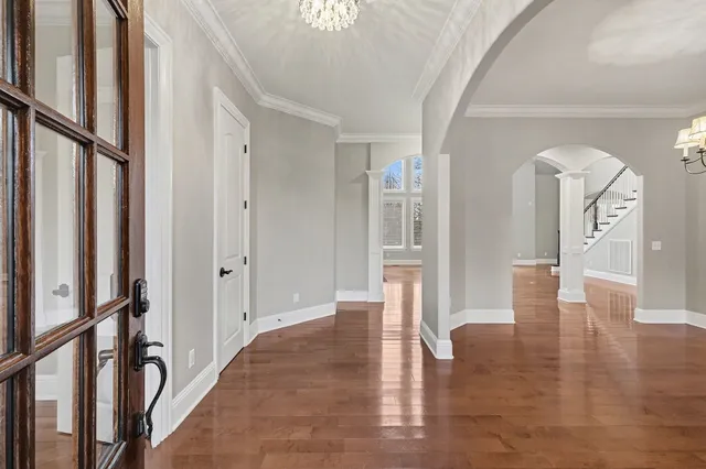 a view of a hallway with wooden floor and staircase