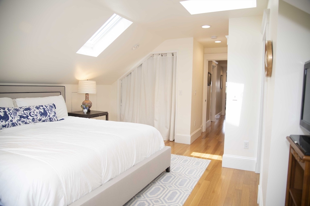3 Chester Road, Unit 3 Belmont, MA 02478 - Photo 17 of 40 a bedroom with a large bed and a chandelier
