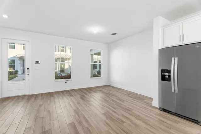 a view of an empty room with a window and wooden floor