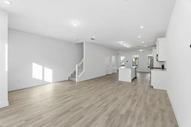 a view of a big room with wooden floor and windows