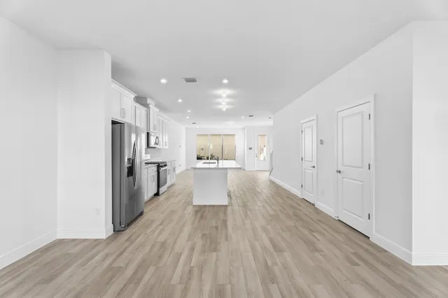 a view of a kitchen with wooden floor and a window