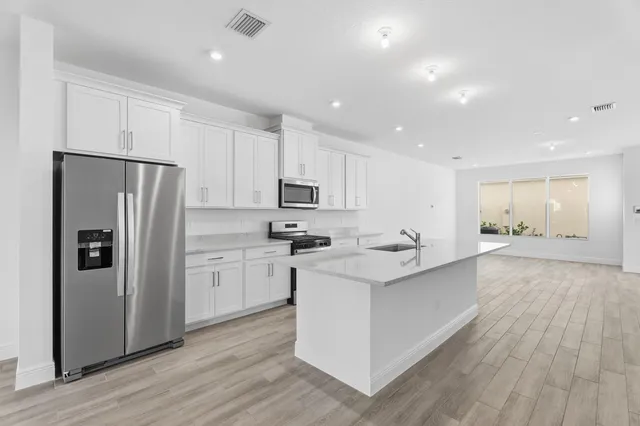 a kitchen with white cabinets and stainless steel appliances