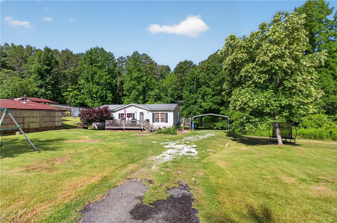 418 Chauga Road Westminster, SC 29693 - Photo 29 of 38 A quaint residence with a metal roof and welcoming deck, nestled amidst a verdant landscape.
