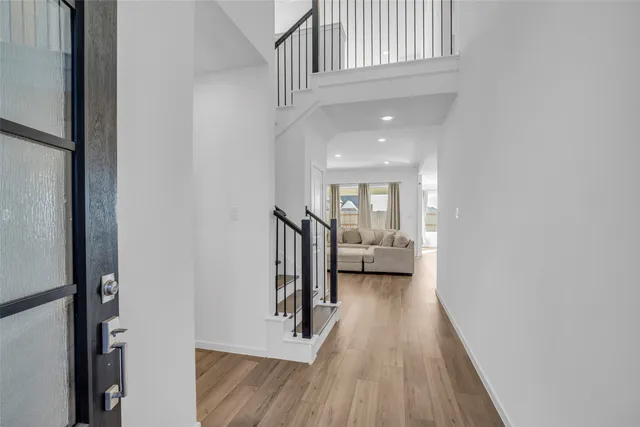 a view of a hallway with wooden floor and staircase