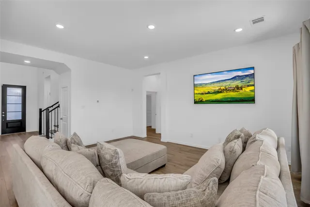 a bedroom with a large bed and a flat tv screen on dresser