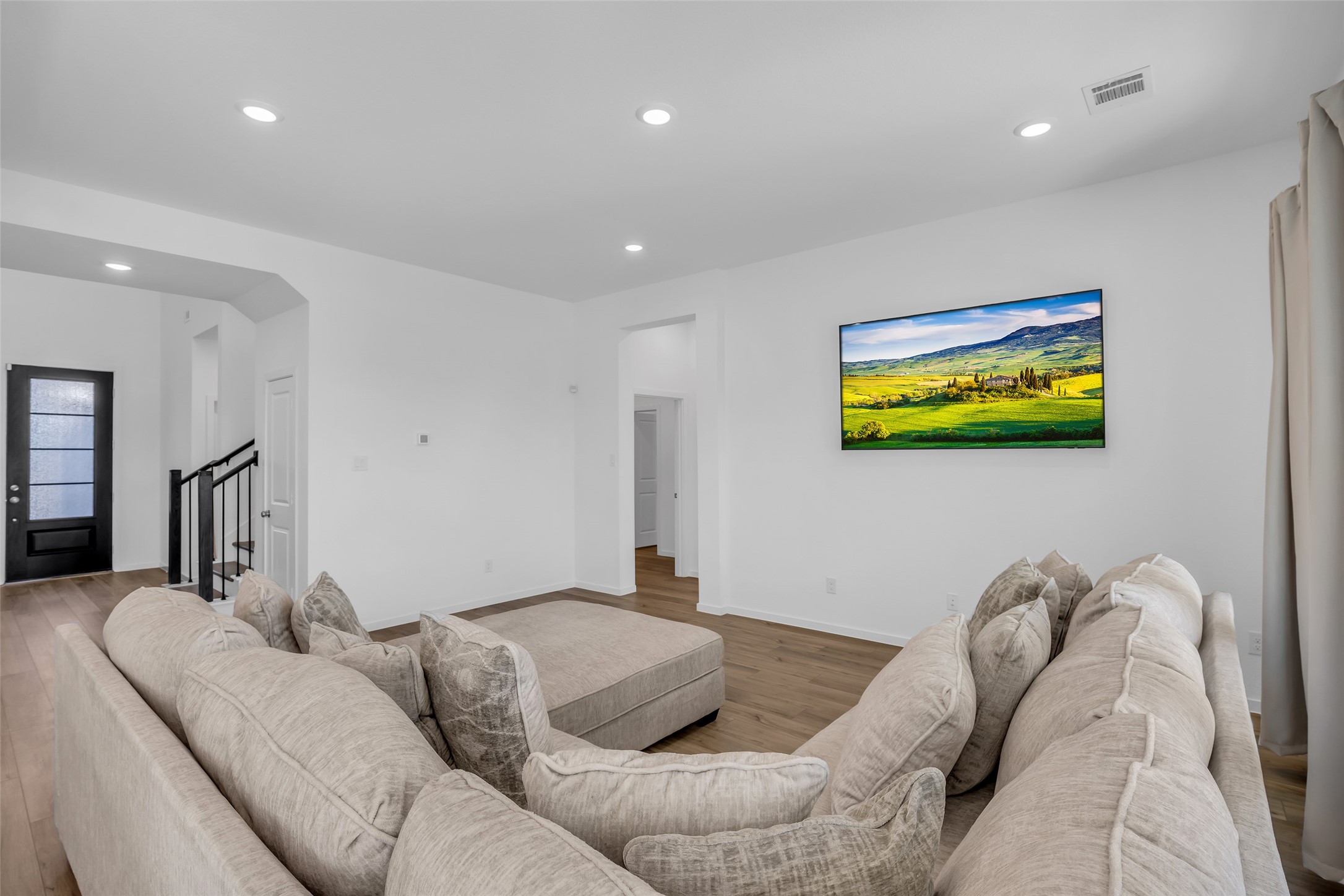 8619 Jade Hl Drive Rosharon, TX 77583 - Photo 26 of 50 Living Area View Toward Primary Suite: From the main living space, a clear path leads directly to the private downstairs primary suite, creating easy separation and everyday convenience. The layout feels open yet intentional, guiding flow without sacrificing comfort.
