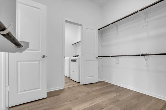 a utility room with wooden floor washer and dryer
