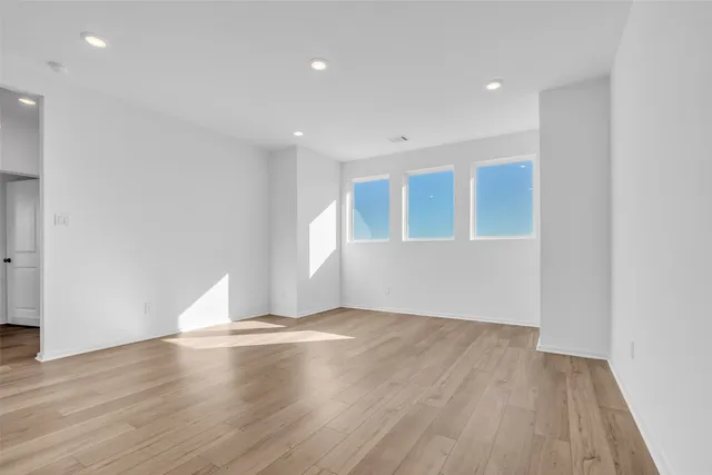 a view of empty room with wooden floor