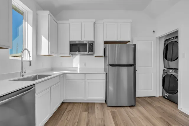 a kitchen with a refrigerator sink and cabinets