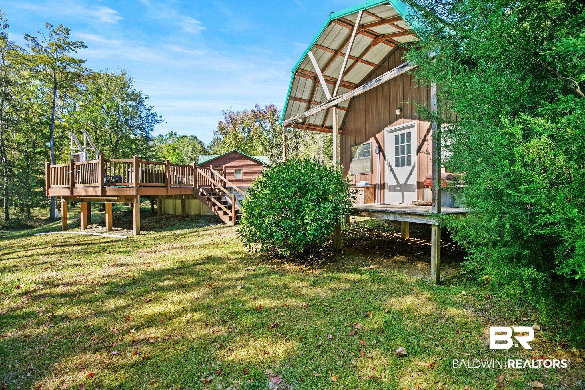 724 Rowell Lane Brewton, AL 36426 - Photo 32 of 40 View of grassy yard with a deck and an outbuilding