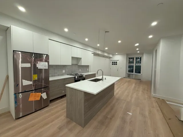 a large kitchen with kitchen island a large counter top space a sink and stainless steel appliances