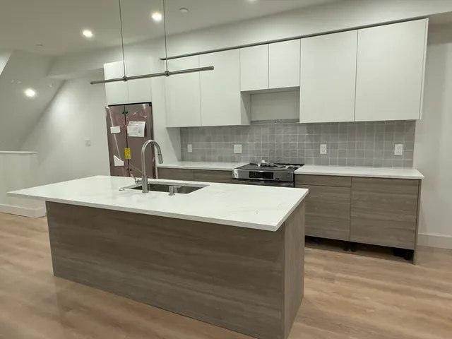a kitchen with a sink cabinets and wooden floor