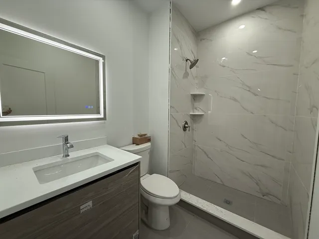 a bathroom with a sink a toilet and shower