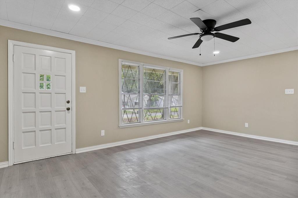 415 Maple Drive Terrell, TX 75160 - Photo 9 of 26 a view of an empty room with a window and a ceiling fan