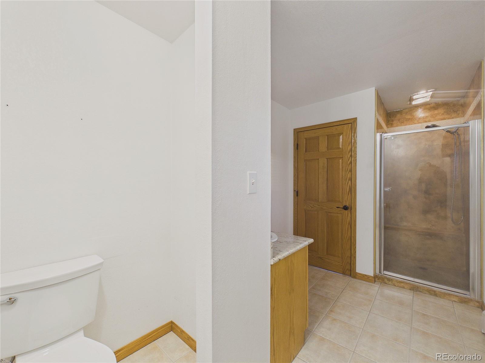 6423 Arrowhead Trail Elizabeth, CO 80107 - Photo 23 of 46 a bathroom with a shower and a toilet