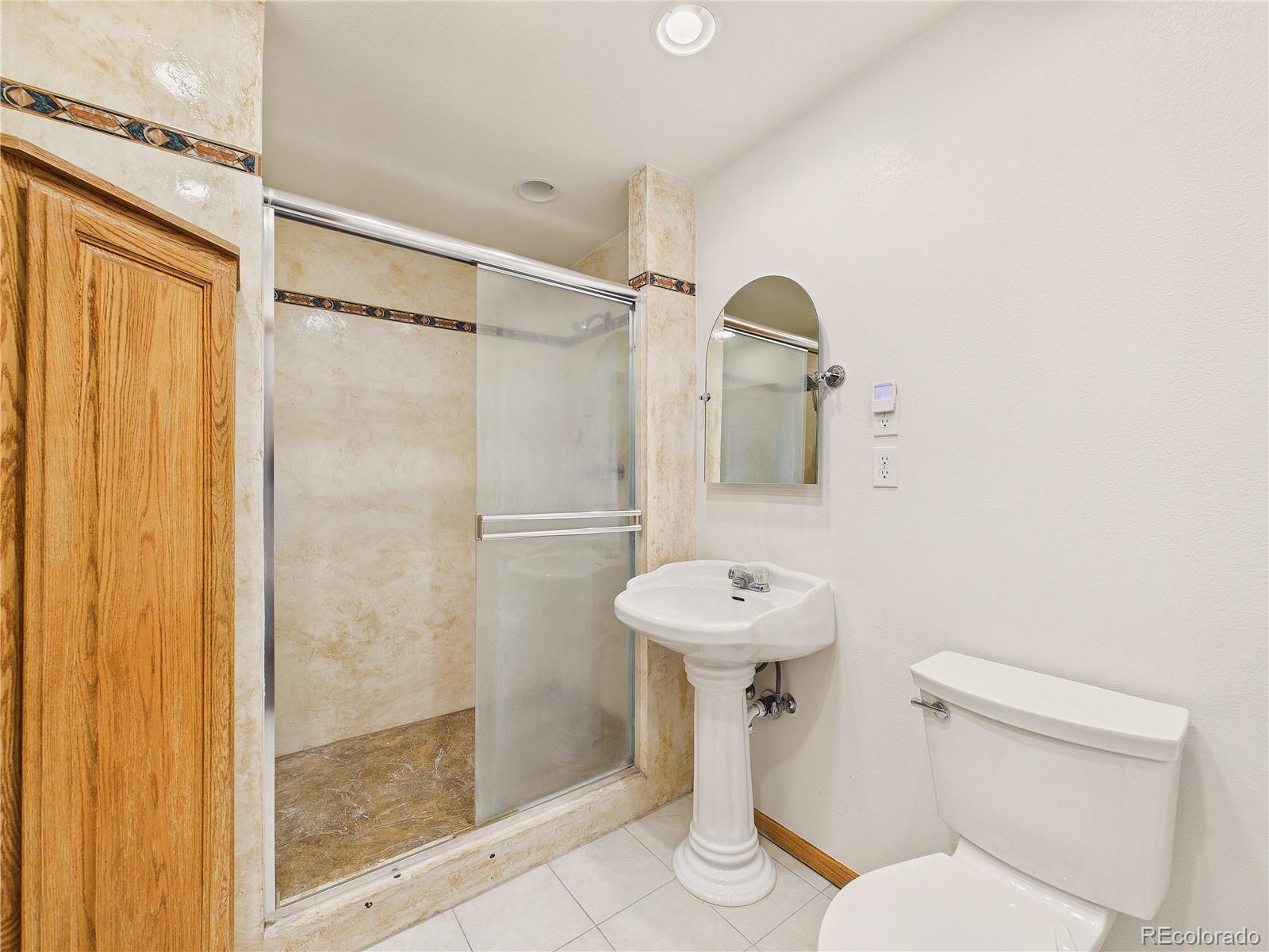 6423 Arrowhead Trail Elizabeth, CO 80107 - Photo 31 of 46 a bathroom with a sink a toilet a mirror and shower
