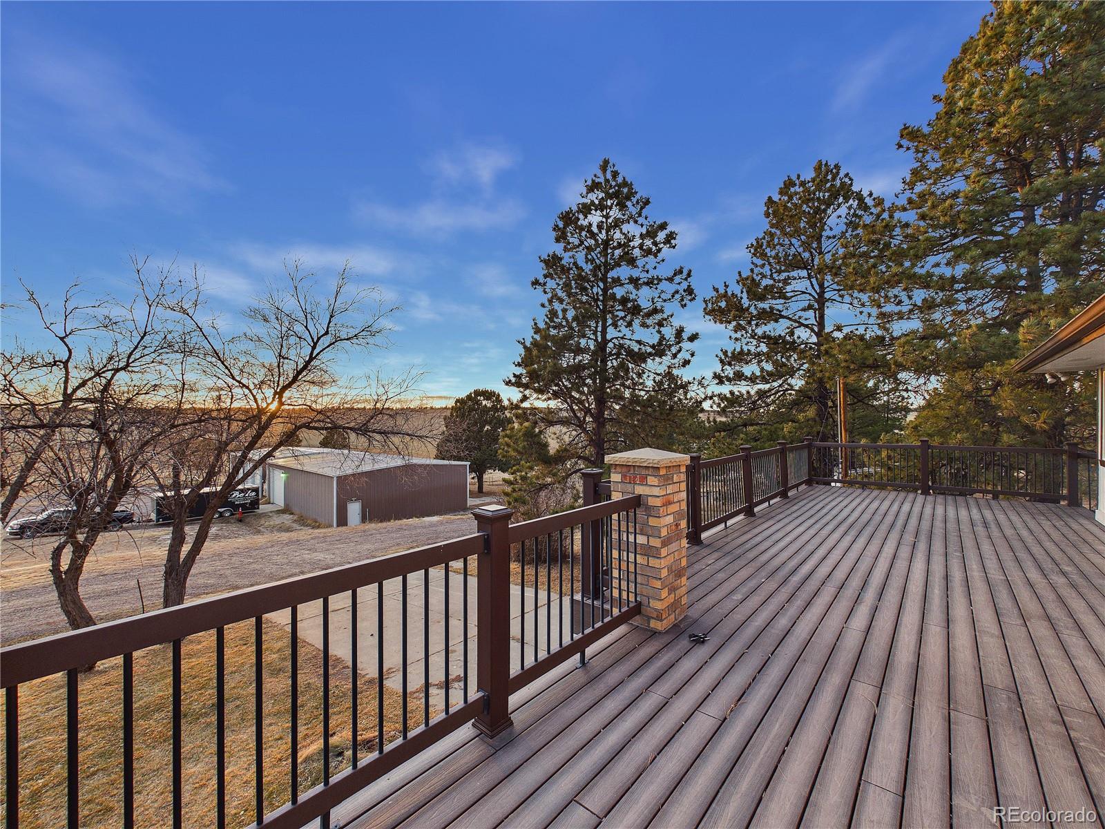 6423 Arrowhead Trail Elizabeth, CO 80107 - Photo 36 of 46 a view of a balcony with wooden floor and fence