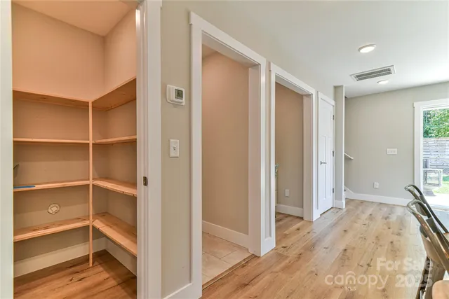 a view of a bedroom with wooden floor and closet