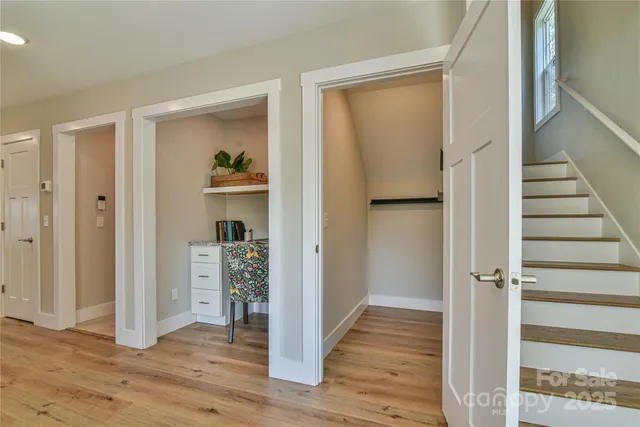 a view of a hallway with wooden floor and closet area