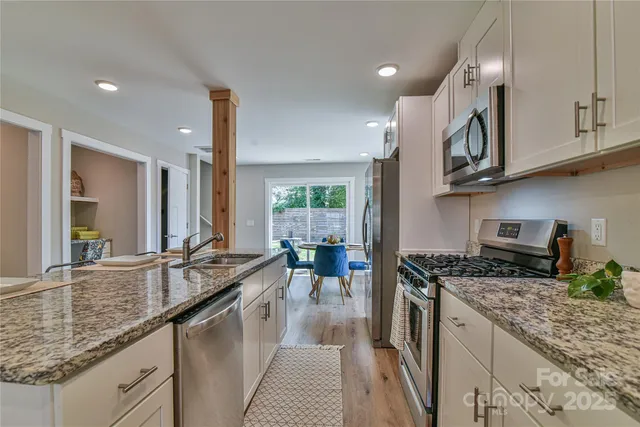 a kitchen with stainless steel appliances granite countertop a sink stove and refrigerator