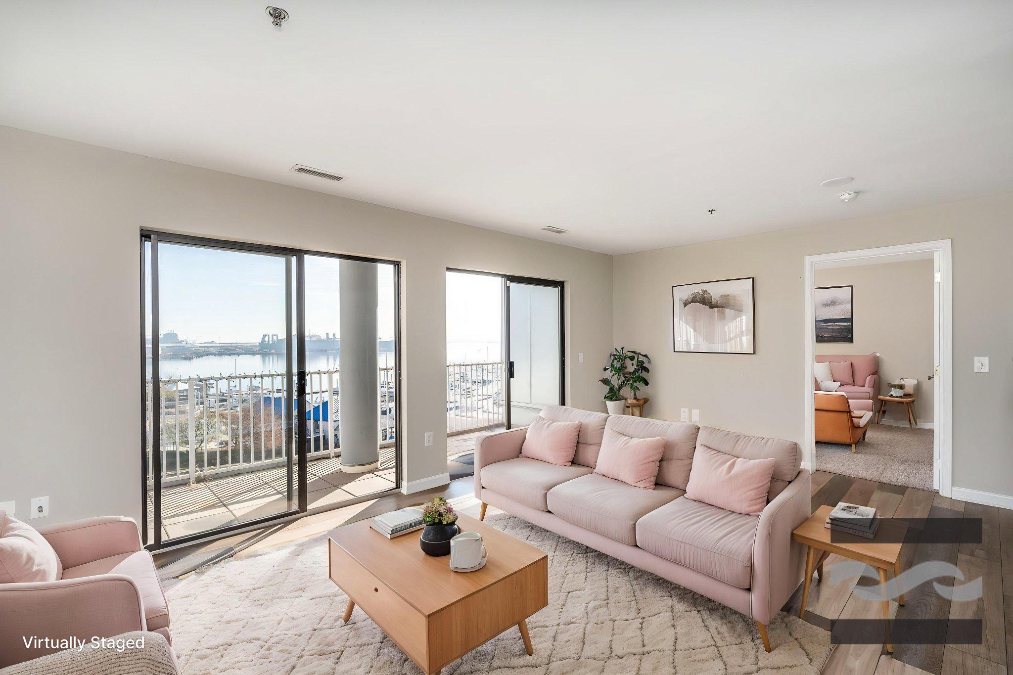 2702 Lighthouse Point East, Unit 532 Baltimore, MD 21224 - Photo 1 of 44 a living room with furniture and a floor to ceiling window