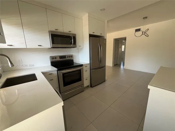 a kitchen with stainless steel appliances granite countertop a refrigerator a stove top oven a sink and dishwasher