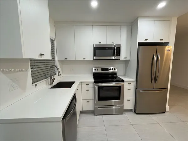 a view of a kitchen with a sink and a refrigerator