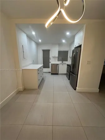 a large kitchen with a large counter top and stainless steel appliances