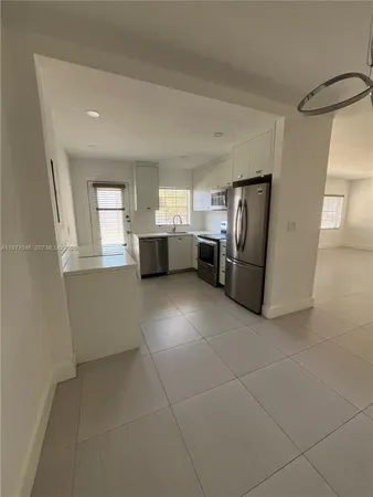 a view of kitchen with refrigerator and window