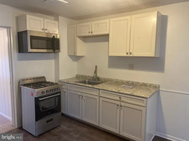 a kitchen with stainless steel appliances granite countertop a sink and a stove