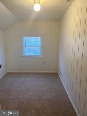 a view of a small space with wooden floor and a window