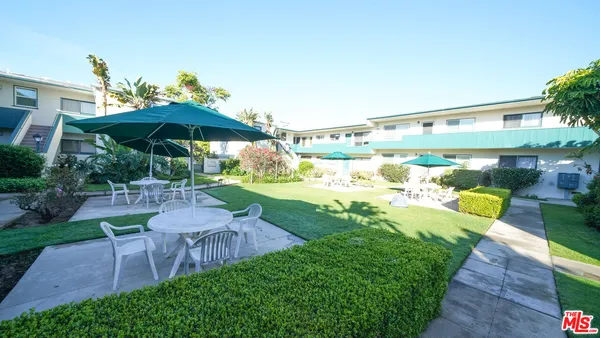 a view of a patio with table and chairs under an umbrella