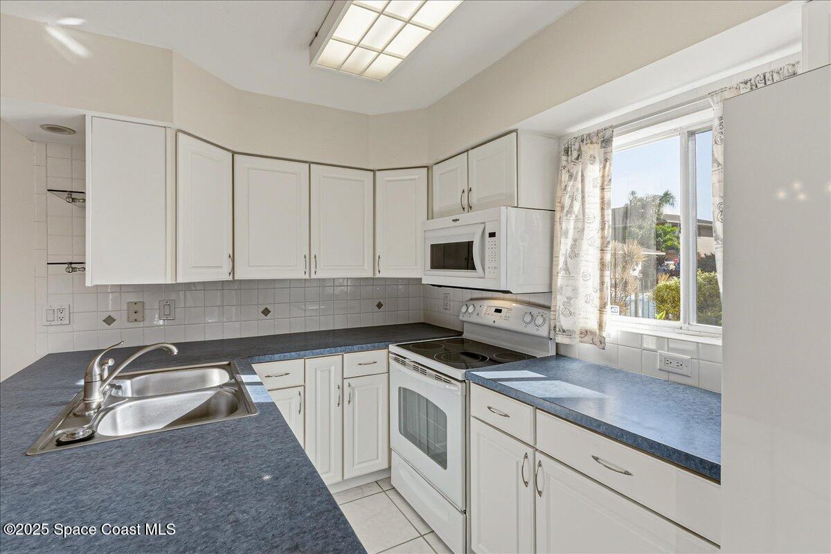 4129 Bond Avenue Rockledge, FL 32955 - Photo 17 of 45 a kitchen with stainless steel appliances granite countertop a sink a stove and a microwave