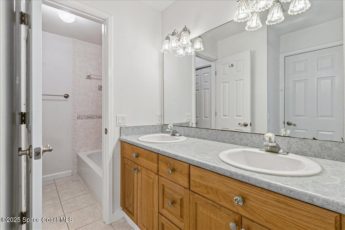 4129 Bond Avenue Rockledge, FL 32955 - Photo 23 of 45 a bathroom with a granite countertop sink a mirror and a shower