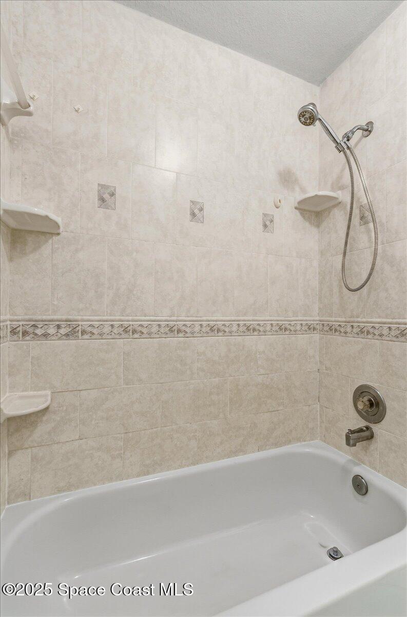 4129 Bond Avenue Rockledge, FL 32955 - Photo 24 of 45 a bath tub sitting next to a white sink and a shower