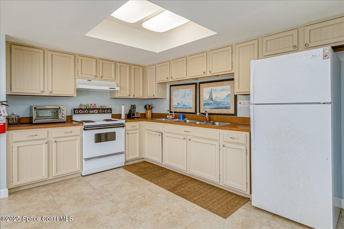 4129 Bond Avenue Rockledge, FL 32955 - Photo 43 of 45 a kitchen with white cabinets and white appliances