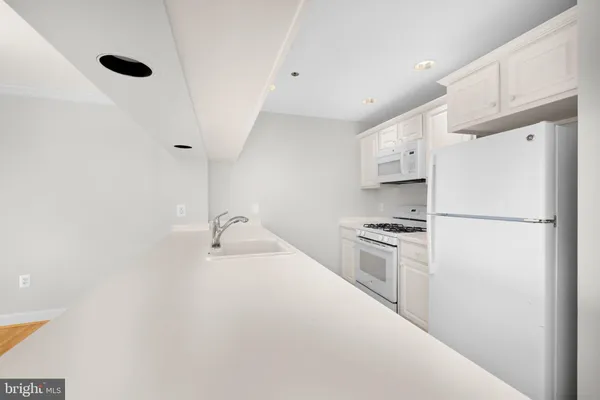 a kitchen with stainless steel appliances a refrigerator sink and stove