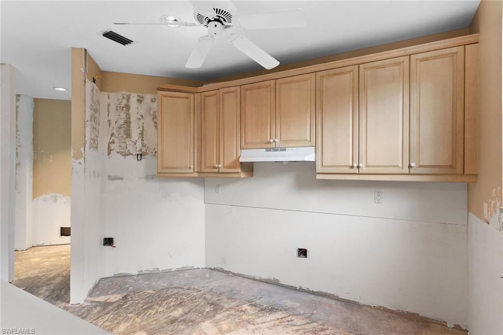 129 Colonade Circle, Unit 402 Naples, FL 34103 - Photo 15 of 36 a view of kitchen with wooden cabinets
