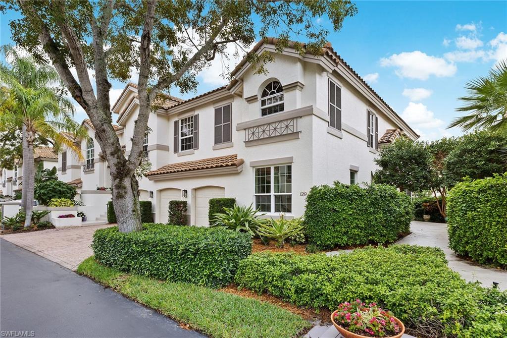 129 Colonade Circle, Unit 402 Naples, FL 34103 - Photo 2 of 36 a view of a white house with a large windows and flower plants
