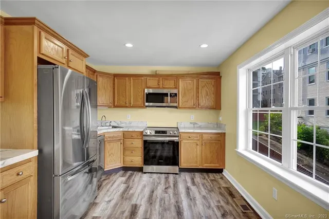 a kitchen with stainless steel appliances granite countertop a stove a sink and a refrigerator