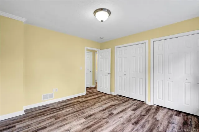 a view of a room with wooden floor and a ceiling fan
