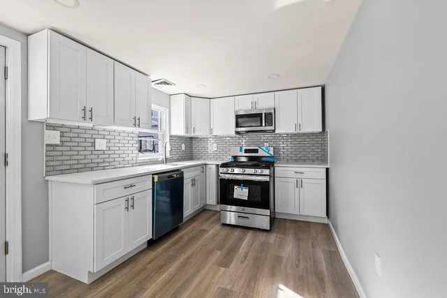 a kitchen with granite countertop a sink cabinets stainless steel appliances and a counter space