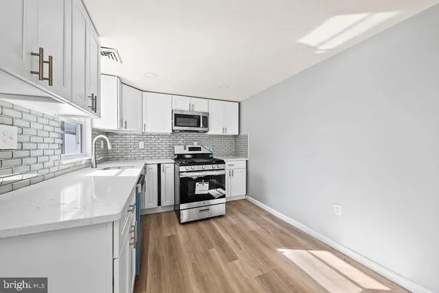 a kitchen with a sink a stove and cabinets