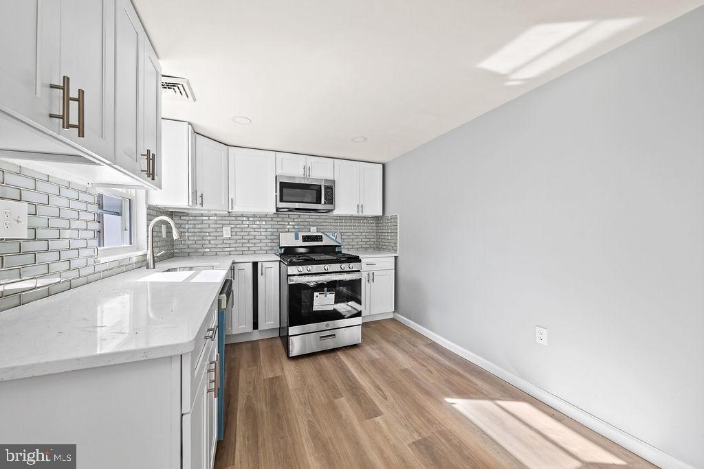 408 West 3rd Avenue Runnemede, NJ 08078 - Photo 3 of 29 a kitchen with a sink a stove and cabinets