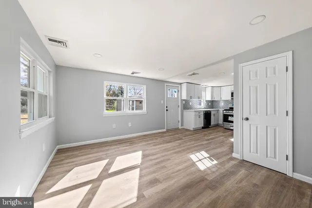 a view of empty room with wooden floor and windows