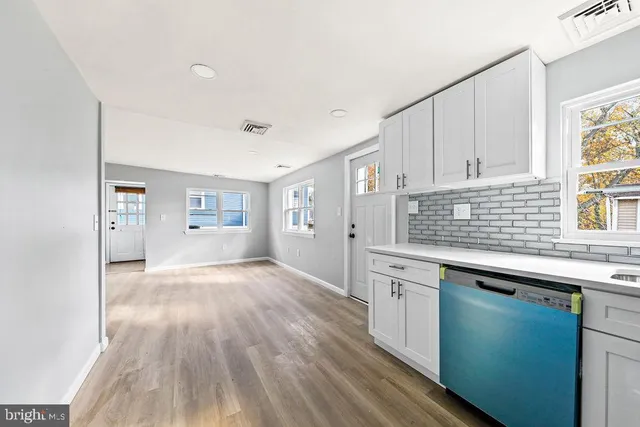 a kitchen with granite countertop white cabinets and white appliances