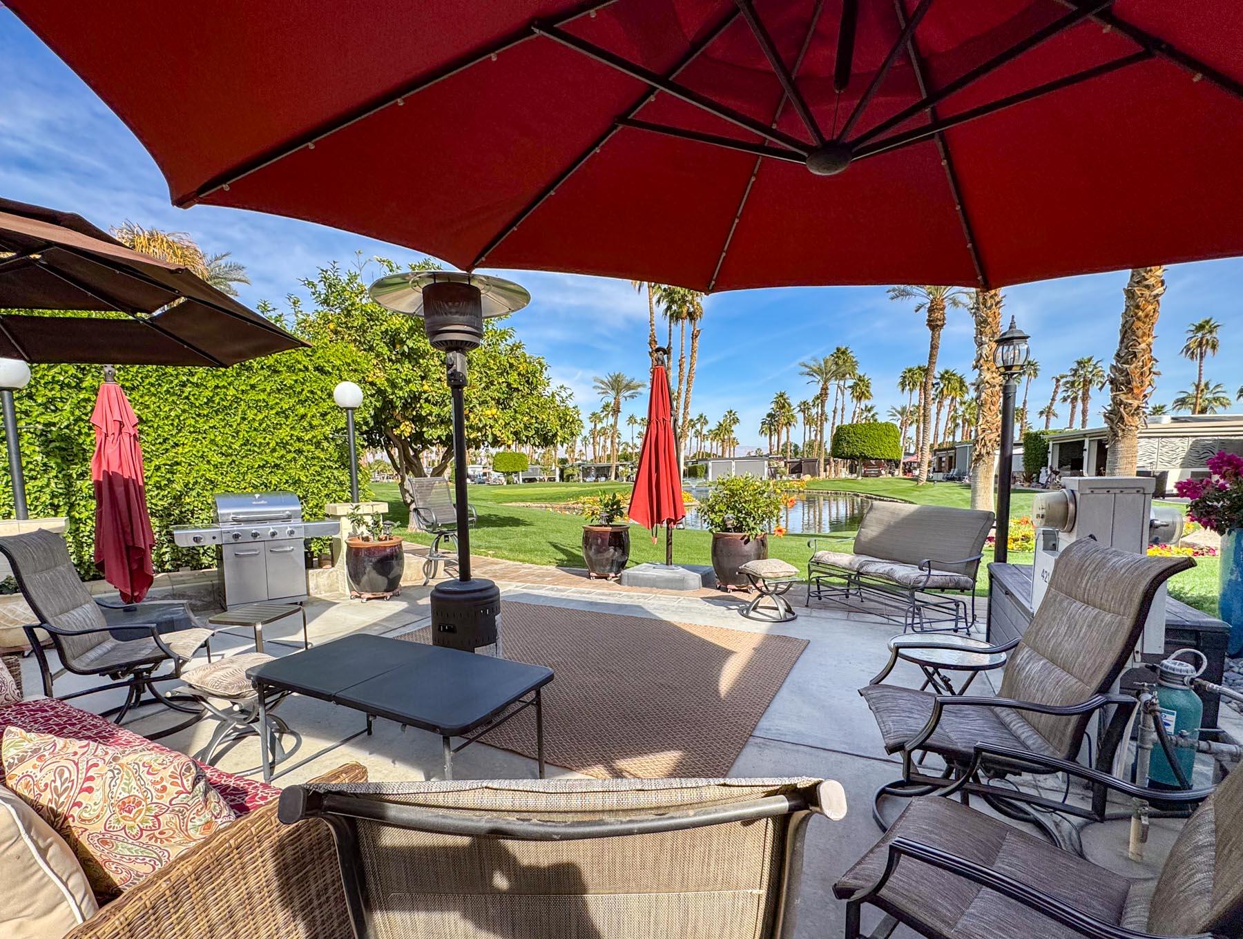 80394 Ave 48, Unit 421 Indio, CA 92201 - Photo 25 of 33 a view of an outdoor sitting area with couch and umbrella